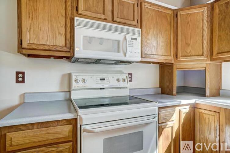 A kitchen with wooden cabinets and white appliances.