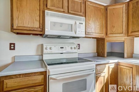 A kitchen with wooden cabinets and white appliances.