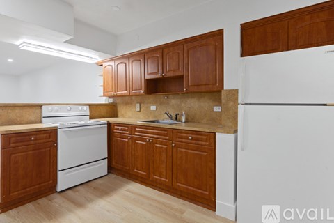 A kitchen with wooden cabinets and a white dishwasher.