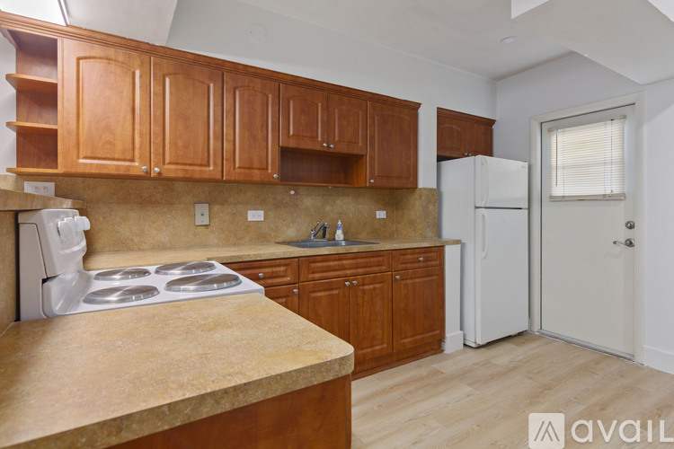 A kitchen with wooden cabinets and a white stove top oven.