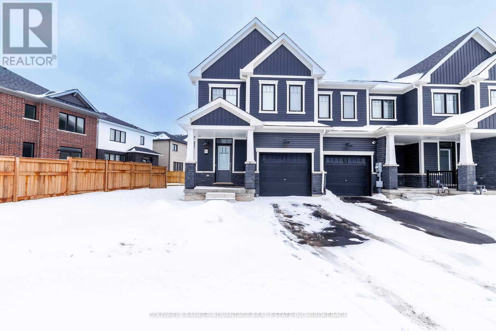 A large house with a garage is surrounded by a snowy landscape.