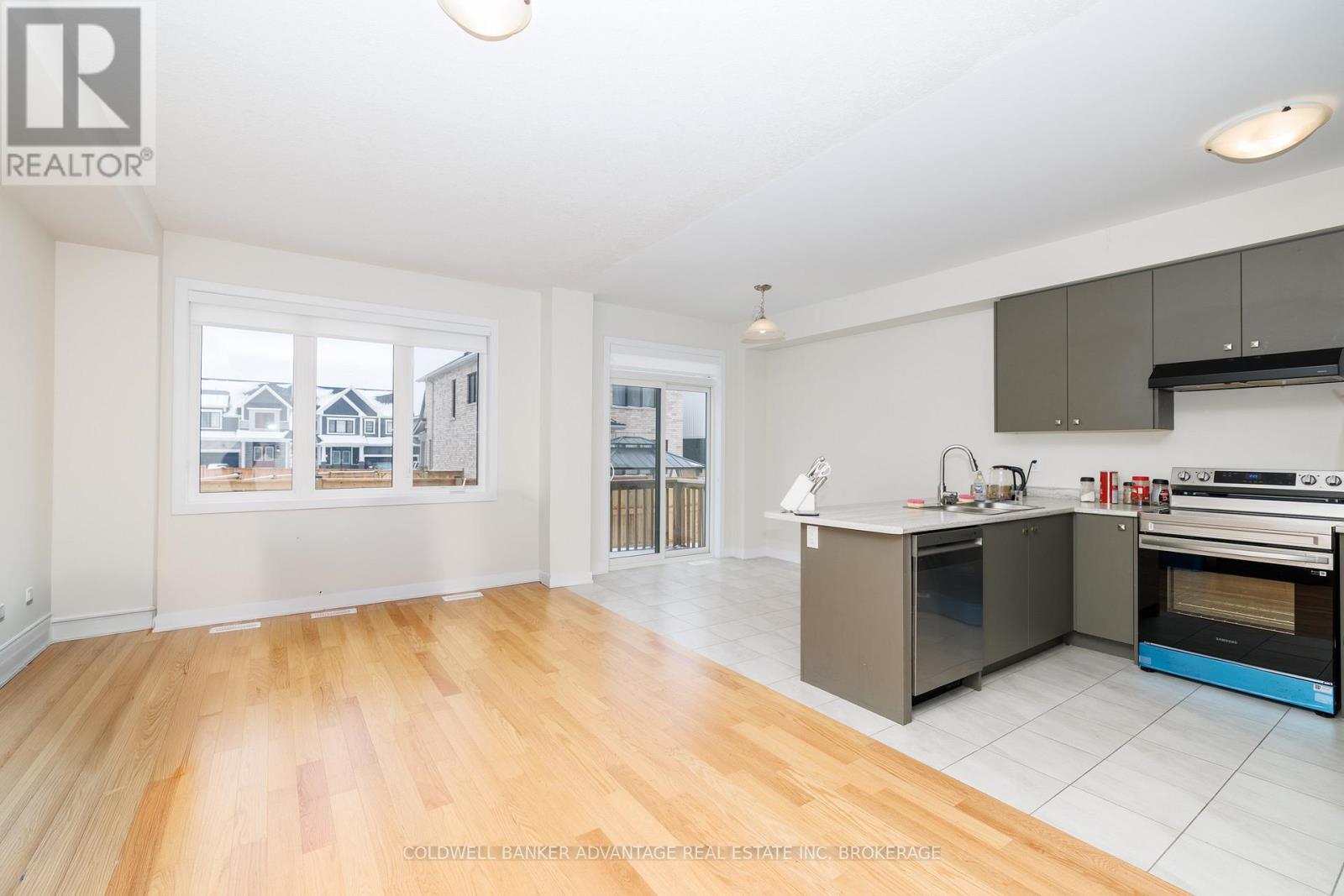 A spacious kitchen with wooden floors and modern appliances.