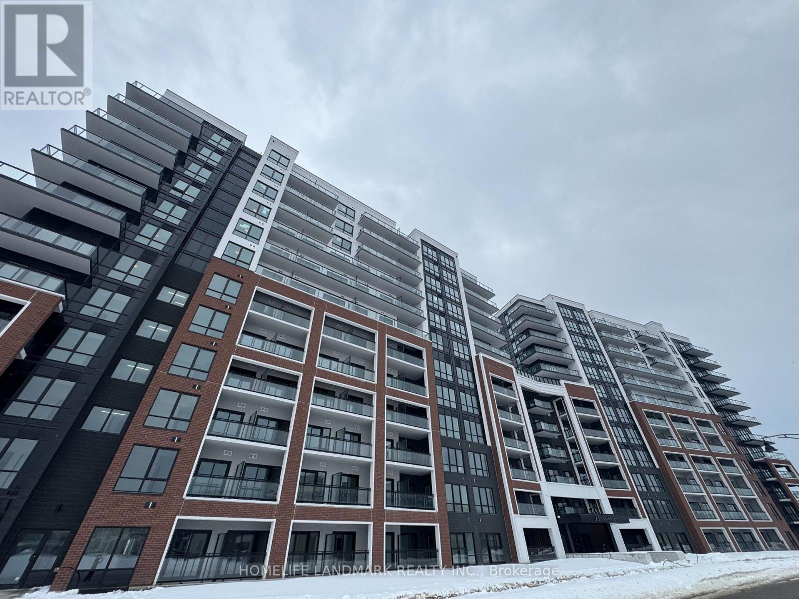 A large, modern residential building with multiple balconies and a mix of brick and glass facades.