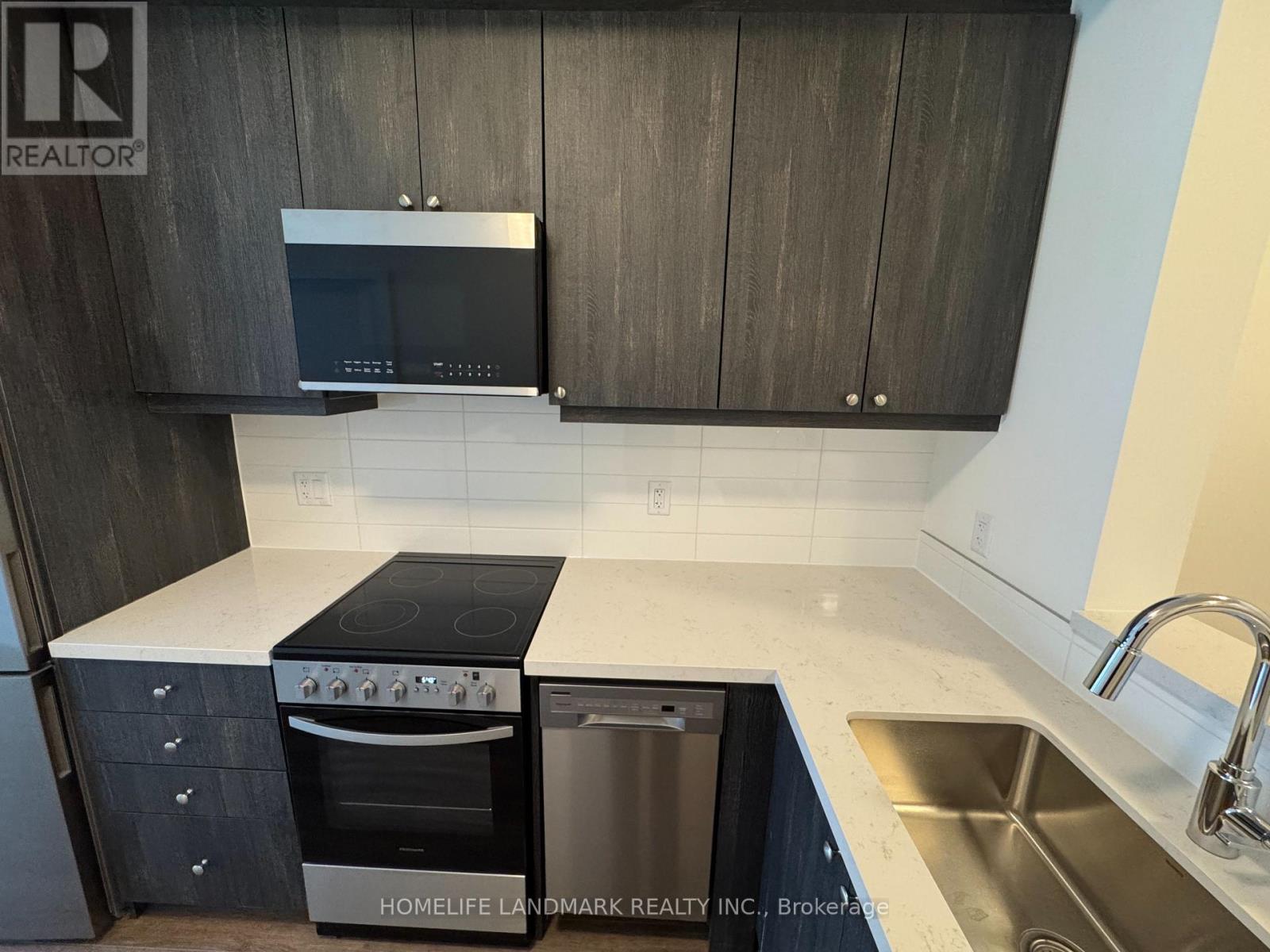 A modern kitchen with dark wood cabinets and stainless steel appliances.
