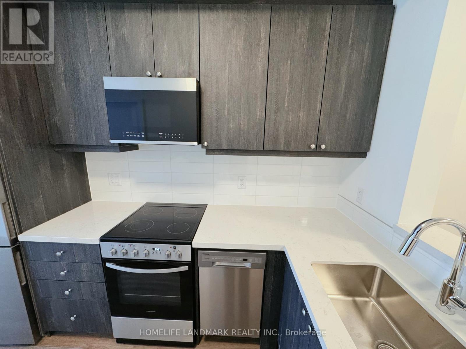 A modern kitchen with dark wood cabinets and stainless steel appliances.