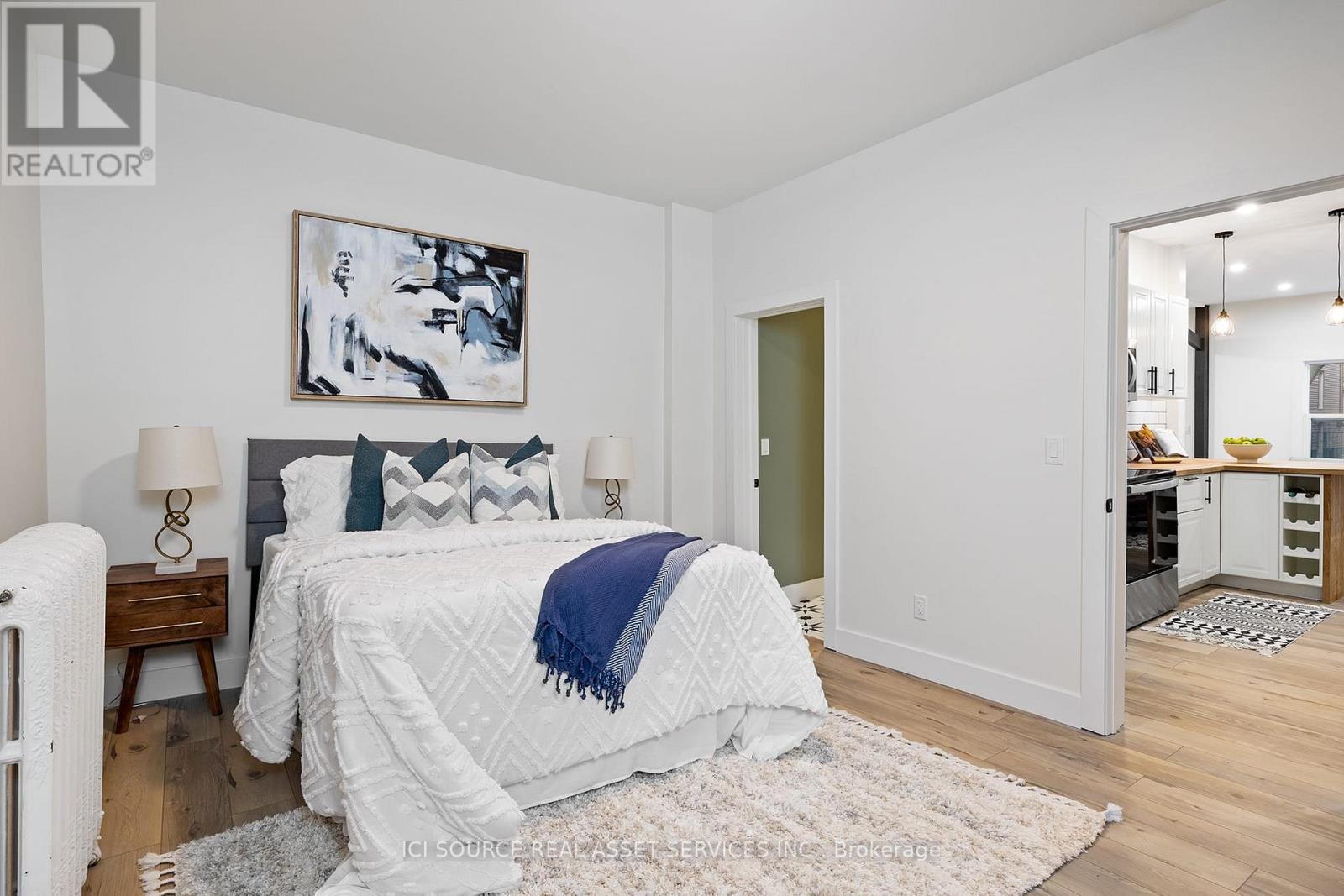 A bedroom with a white bed and a blue blanket.