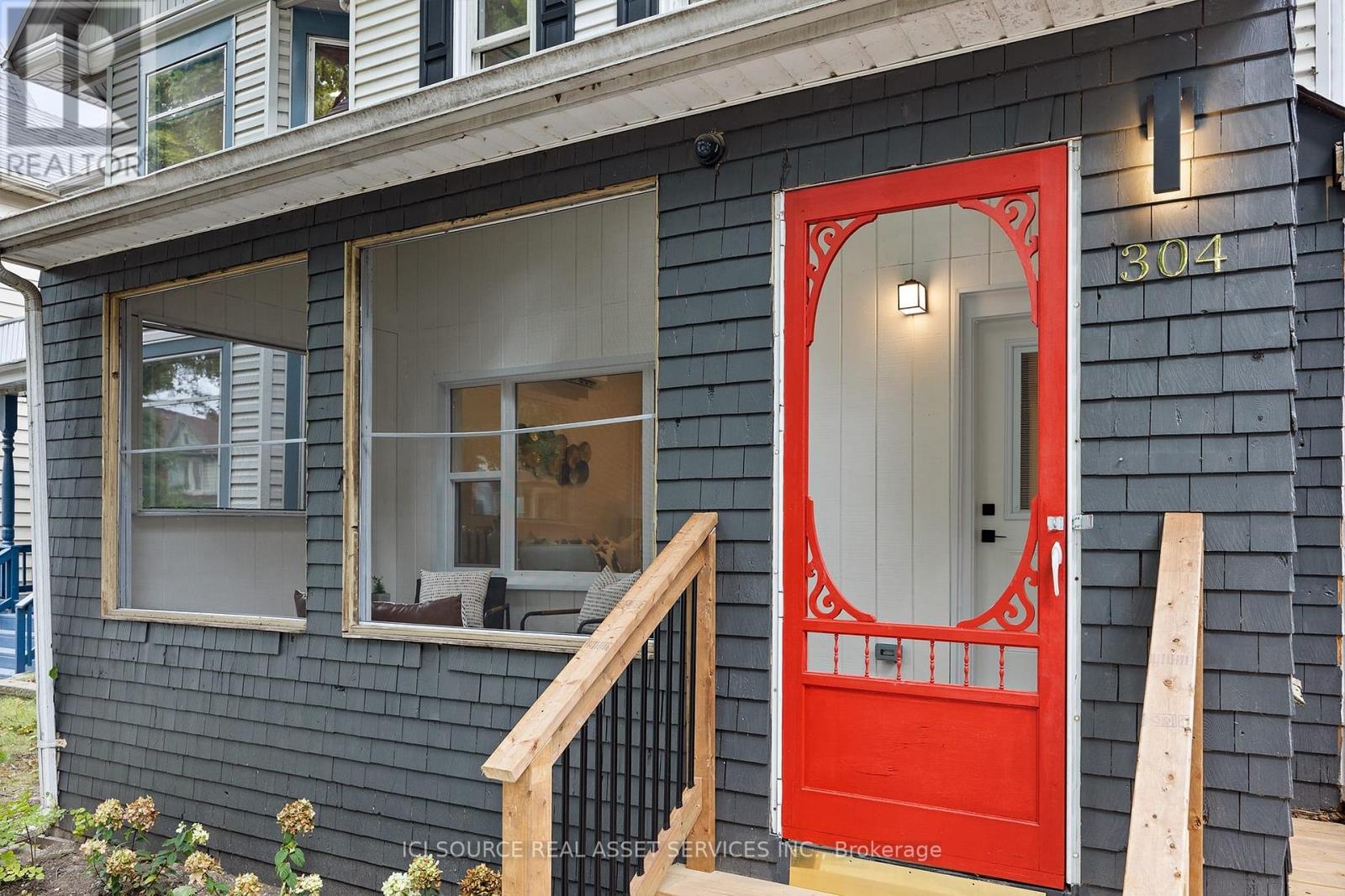 A red door with a window above it and a number 304 on the wall.