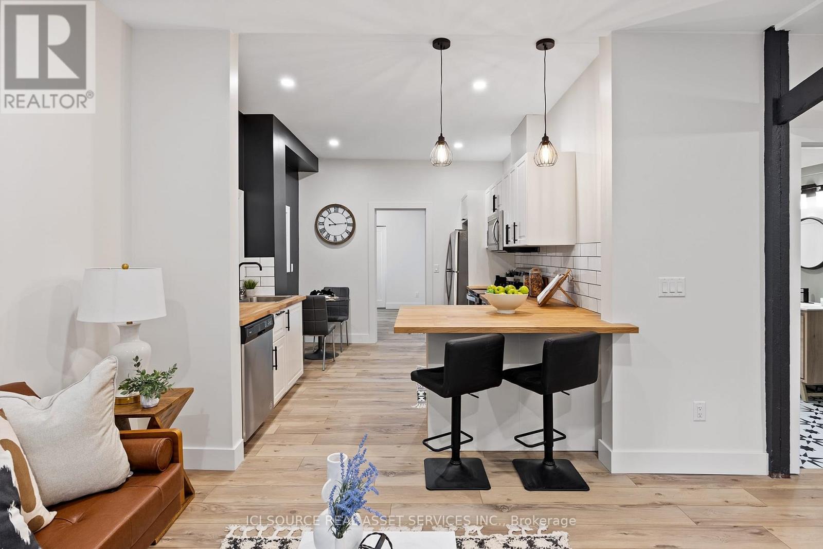 A modern kitchen with a wooden table and black chairs.