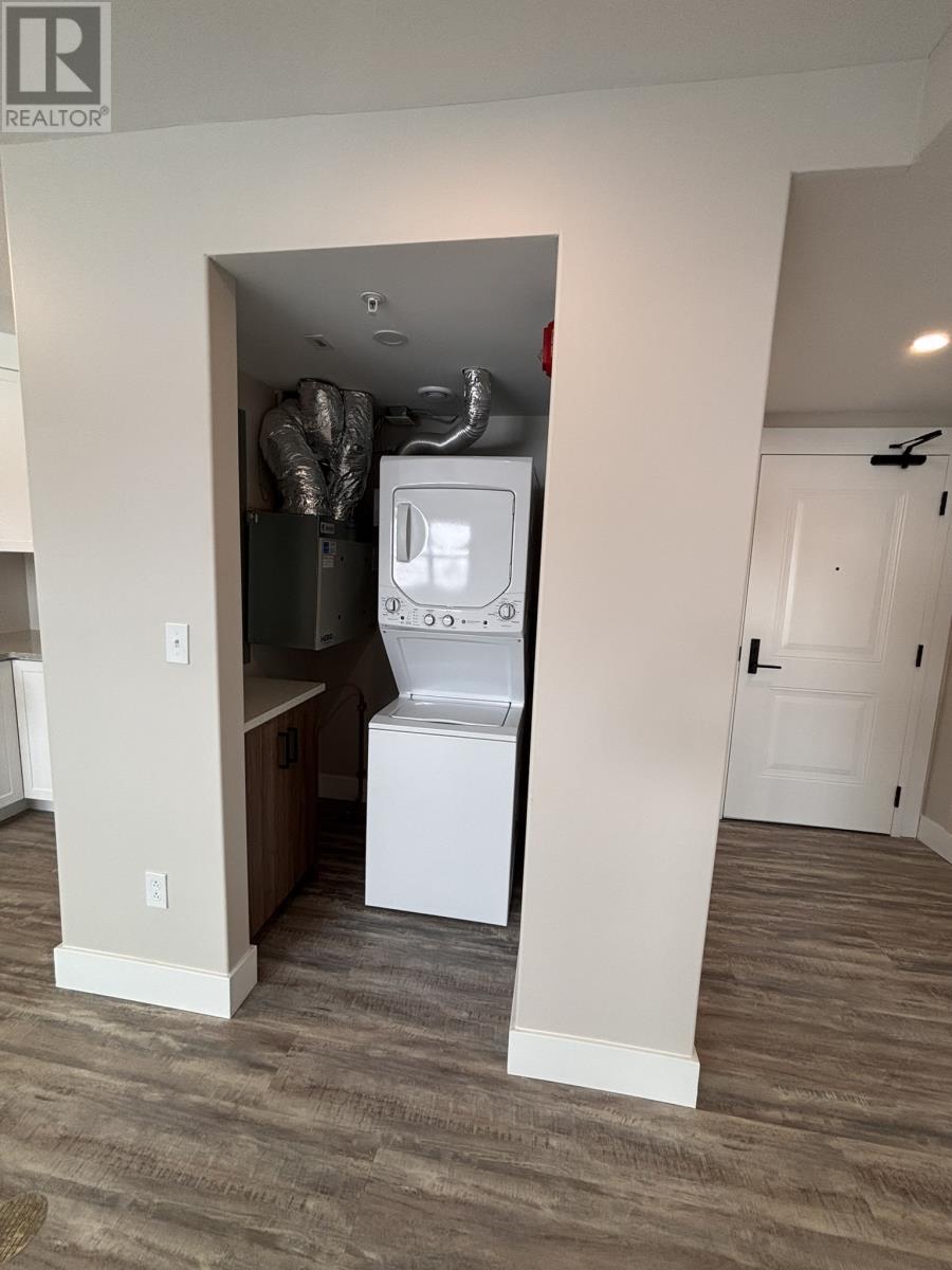 A small white washer and dryer are in a narrow alcove.