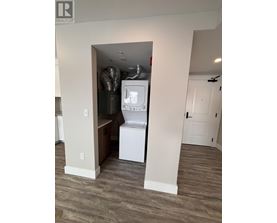 A small white washer and dryer are in a narrow alcove.