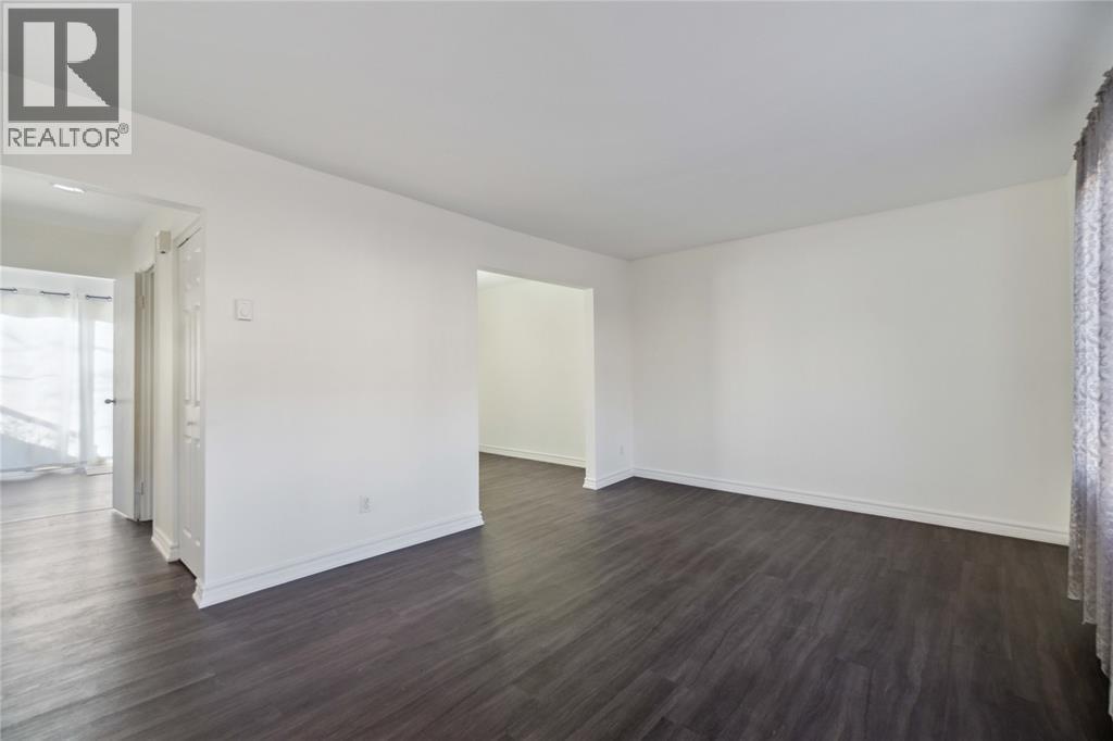 A large empty room with wooden floors and white walls.