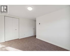 A bedroom with a carpet and a white door.