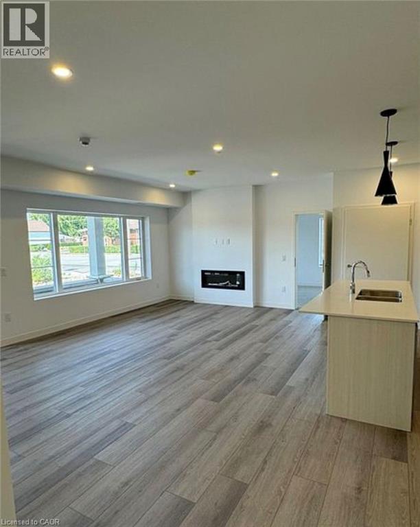 A spacious room with a kitchen area and a large window.
