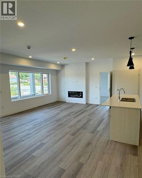 A spacious room with a kitchen area and a large window.