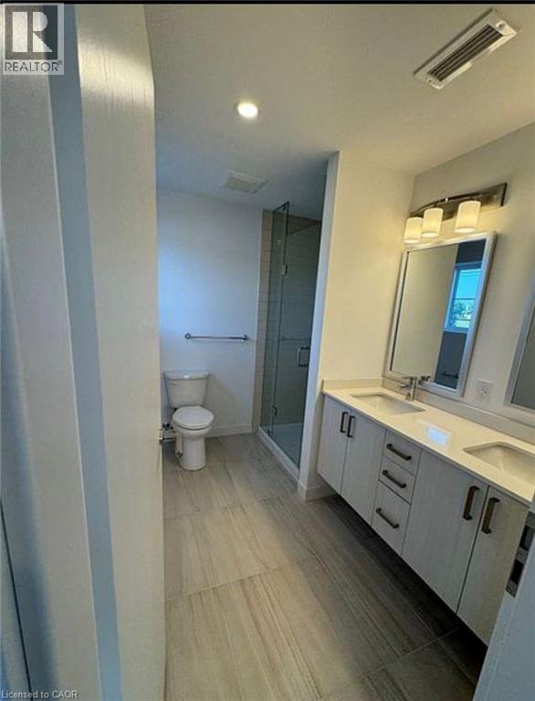 A bathroom with a toilet, sink, and mirror.