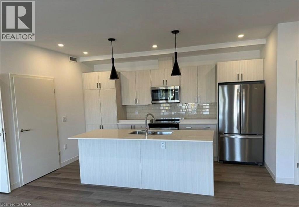 A modern kitchen with a white island and stainless steel appliances.