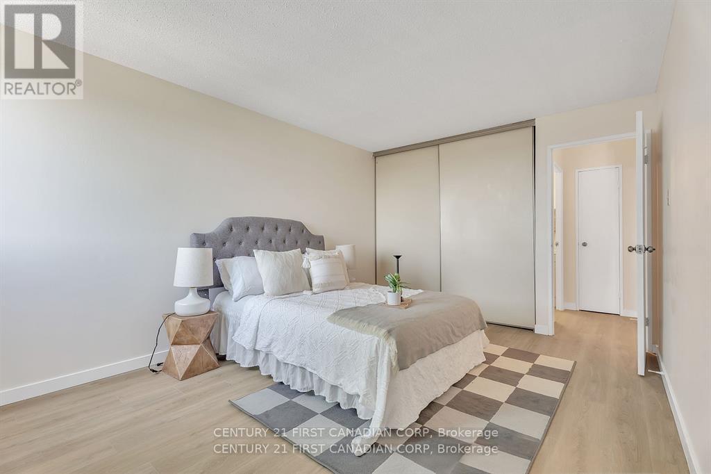 A bedroom with a bed, nightstand, and lamp.