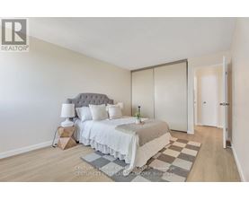 A bedroom with a bed, nightstand, and lamp.