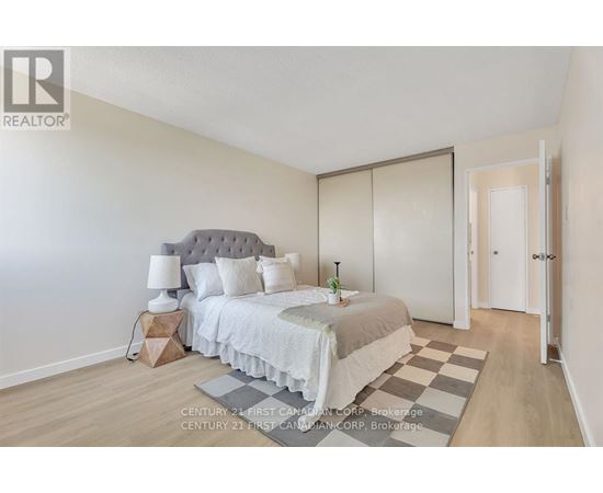 A bedroom with a bed, nightstand, and lamp.