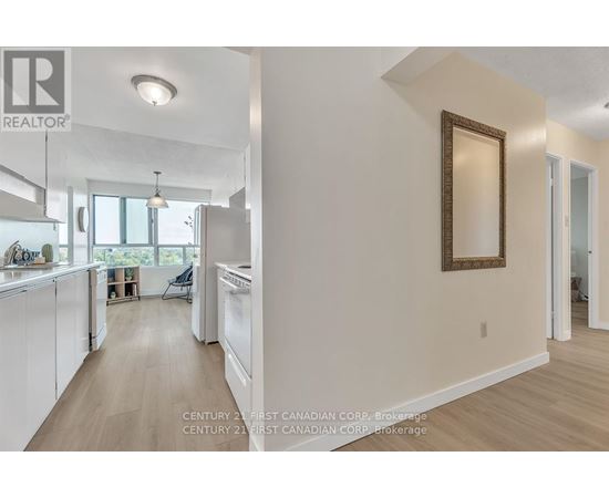 A kitchen with white appliances and wooden floors.