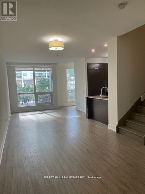 A spacious room with a staircase leading to the upper floor.