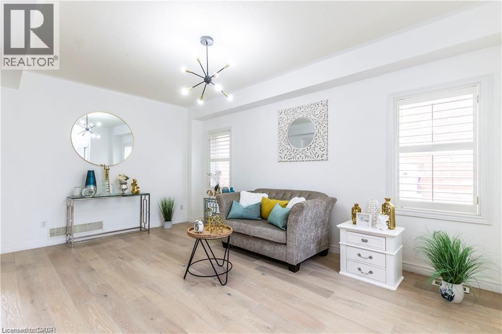 A living room with a grey couch, a coffee table, and a mirror on the wall.