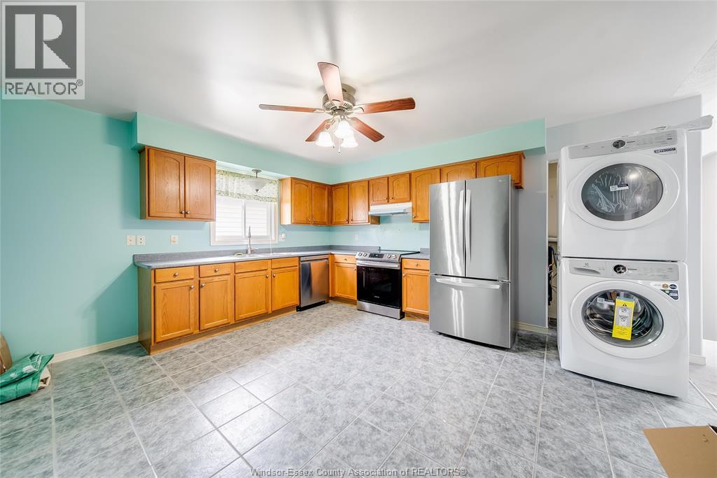 A kitchen with a refrigerator and washing machine in it.