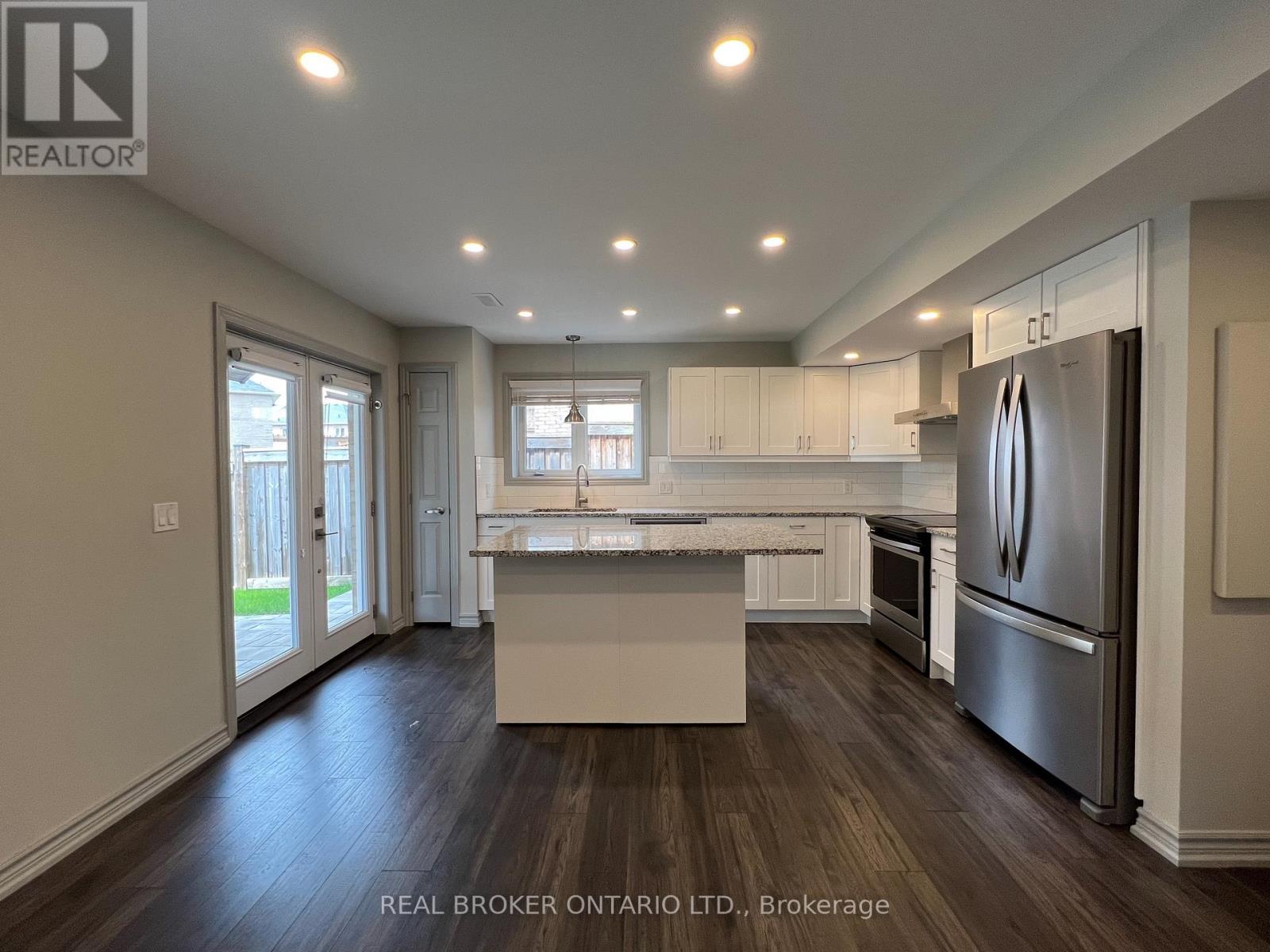 A modern kitchen with a refrigerator on the right side.