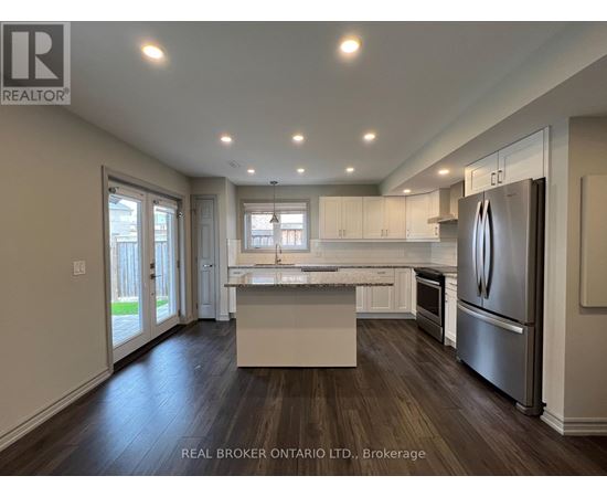 A modern kitchen with a refrigerator on the right side.