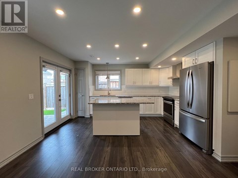 A modern kitchen with a refrigerator on the right side.