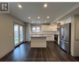 A kitchen with a granite countertop and wooden floors.