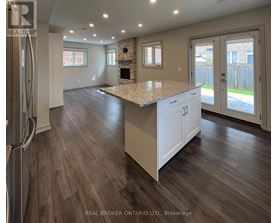 A stone fireplace in a room with wood flooring and a window.