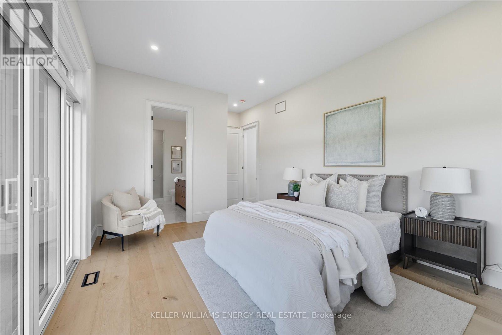 A bedroom with a large bed and a painting on the wall.