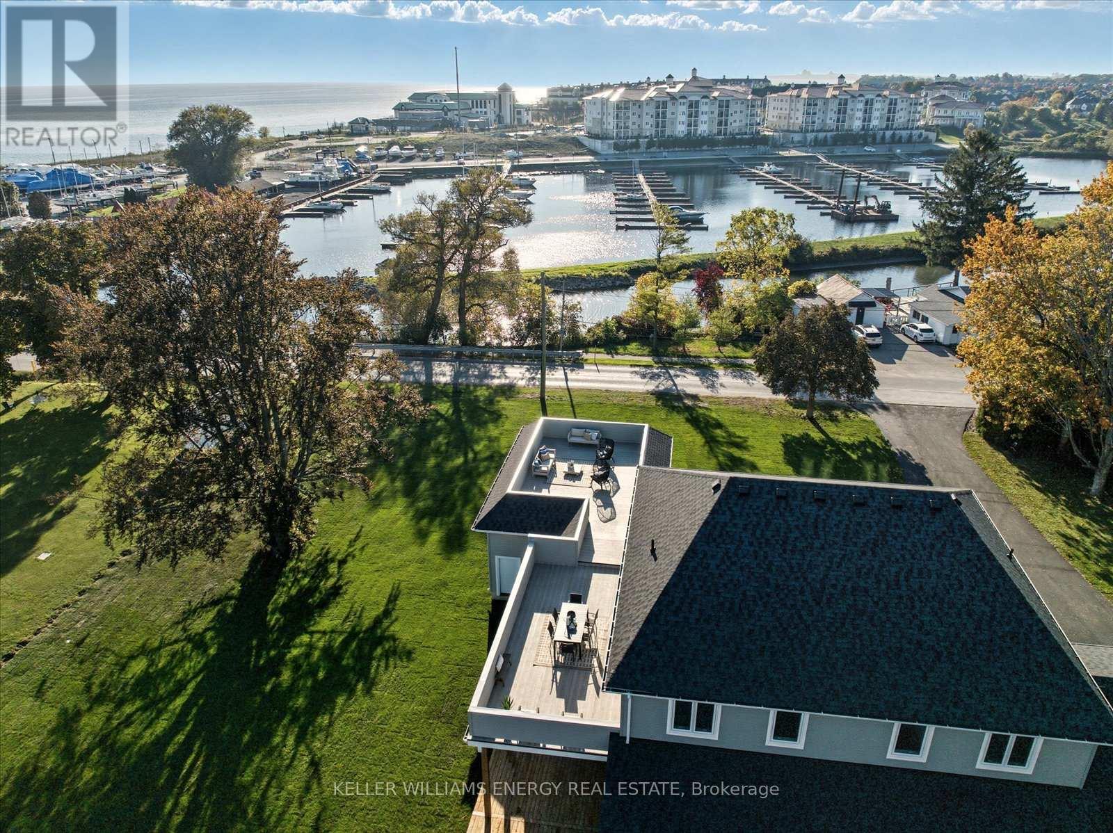 A real estate company's office is shown in the foreground with a marina and buildings in the background.