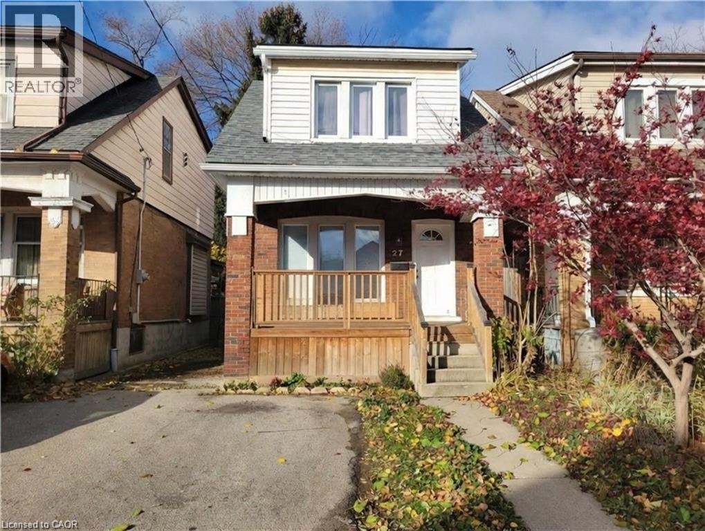 A house with a front yard and a tree with red leaves.