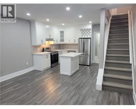 A well-lit kitchen with a refrigerator, stove, and cabinets.