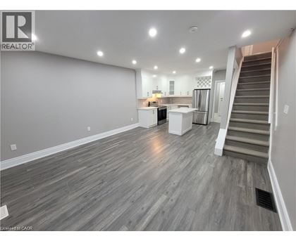 A spacious living room with a staircase leading to the upper floor.