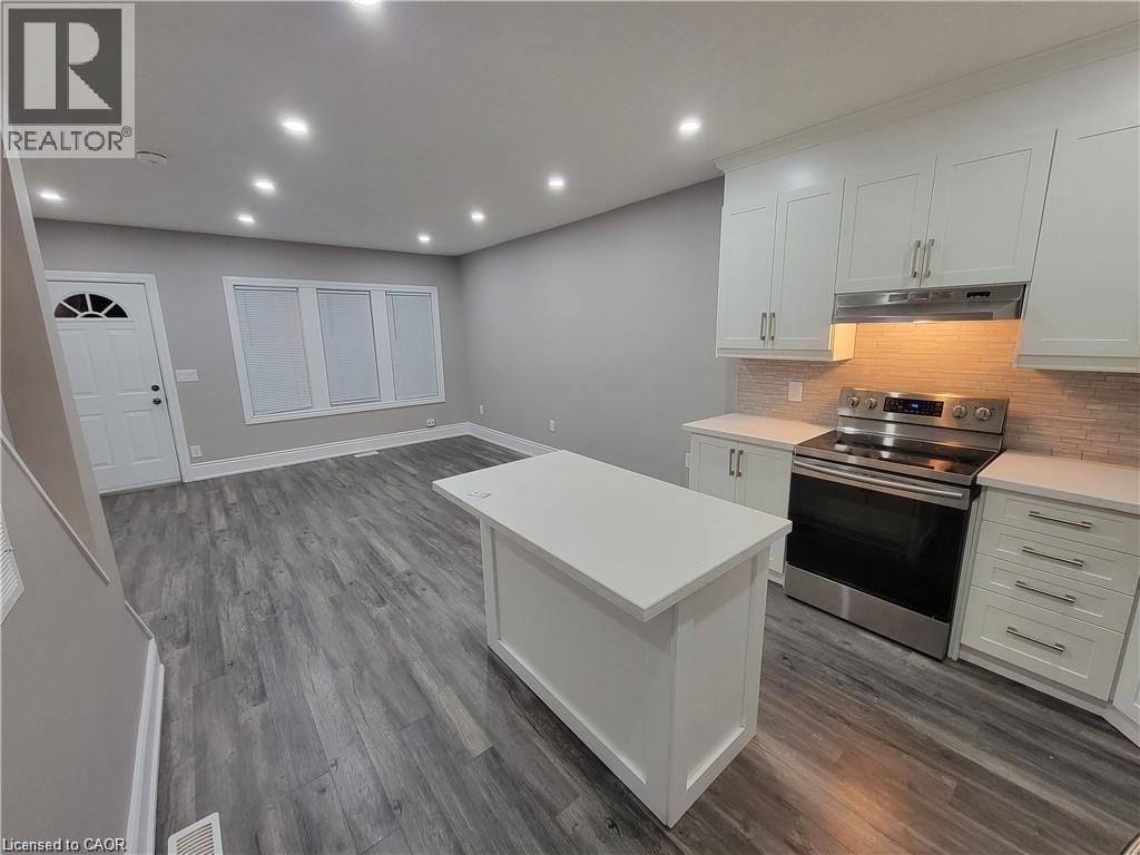 A kitchen with white cabinets and a wooden floor.