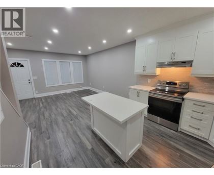 A kitchen with white cabinets and a wooden floor.