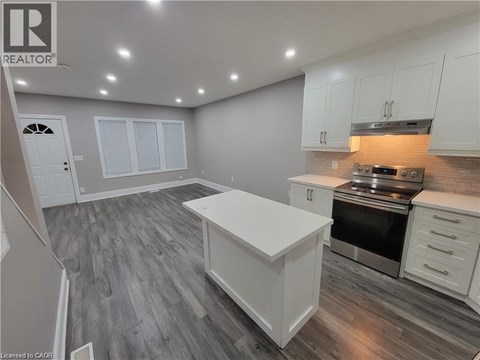 A kitchen with white cabinets and a wooden floor.