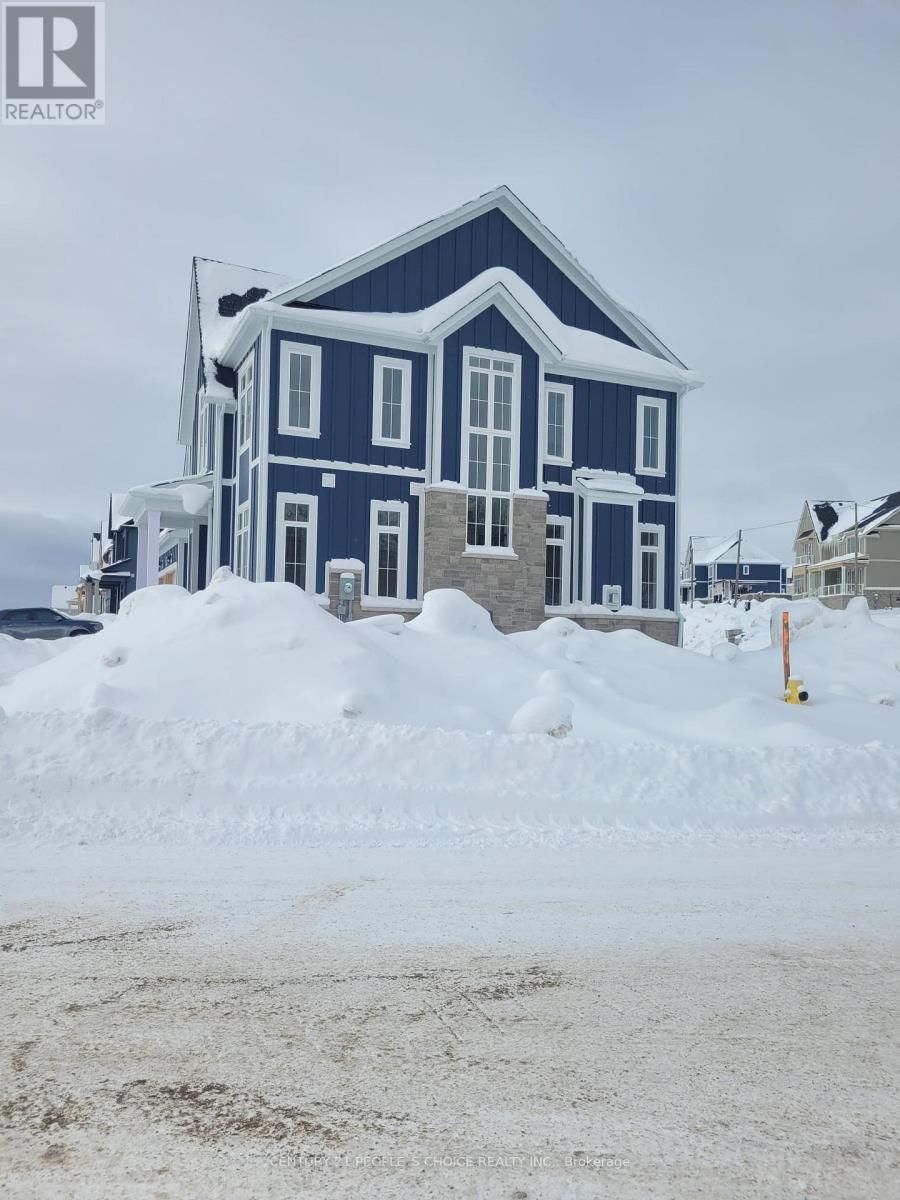 A blue house with a large snow pile in front.