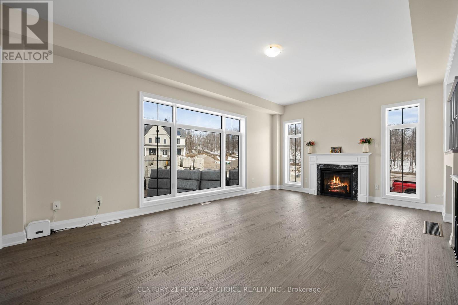 A spacious living room with a fireplace and large windows.