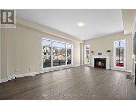 A spacious living room with a fireplace and large windows.
