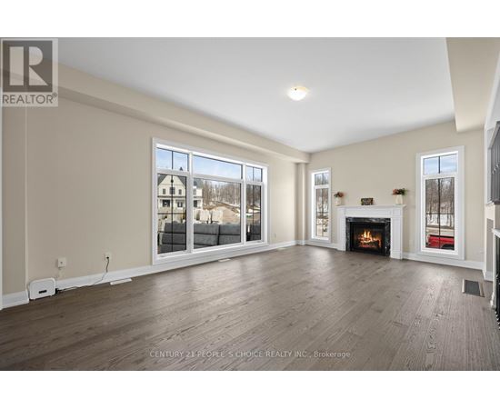 A spacious living room with a fireplace and large windows.