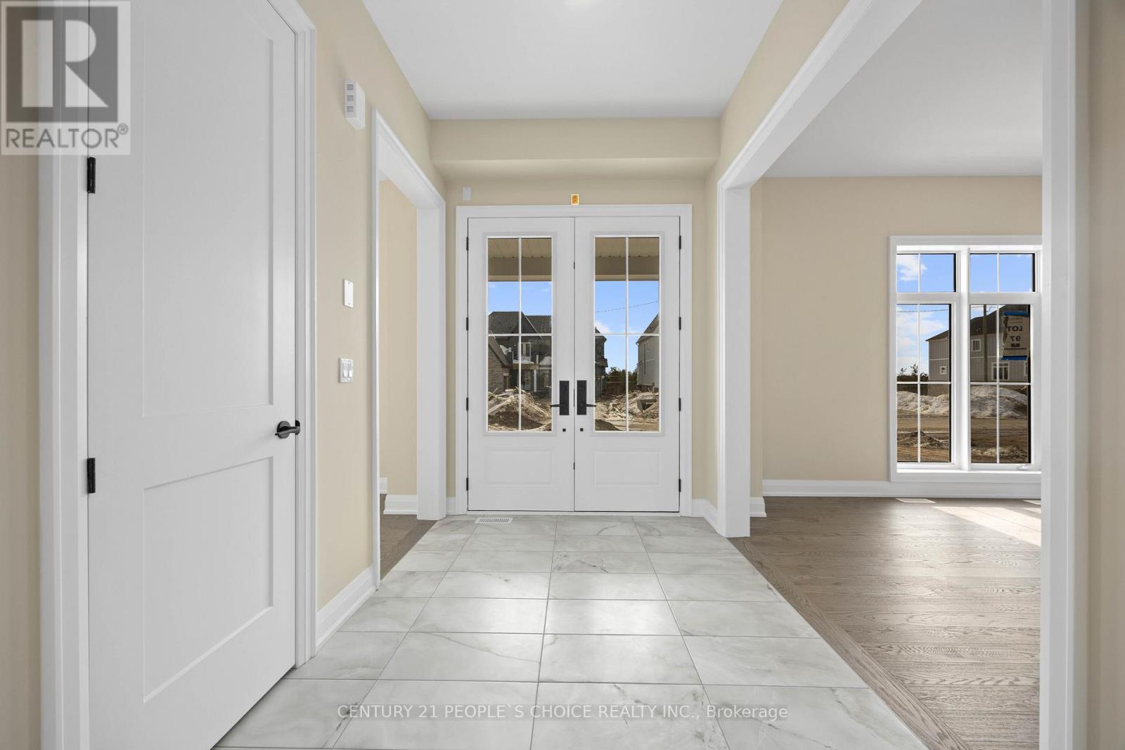 A spacious hallway with a tiled floor and white doors.