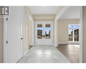 A spacious hallway with a tiled floor and white doors.
