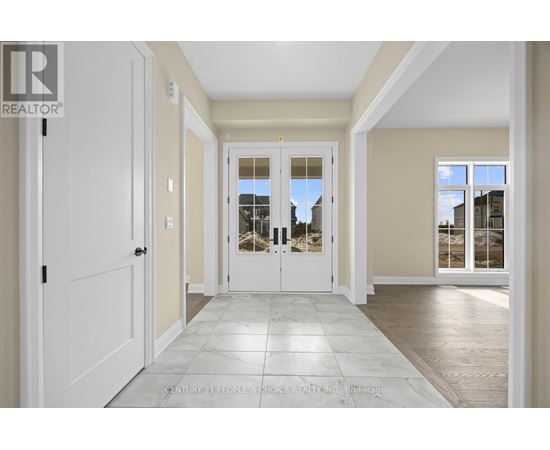 A spacious hallway with a tiled floor and white doors.
