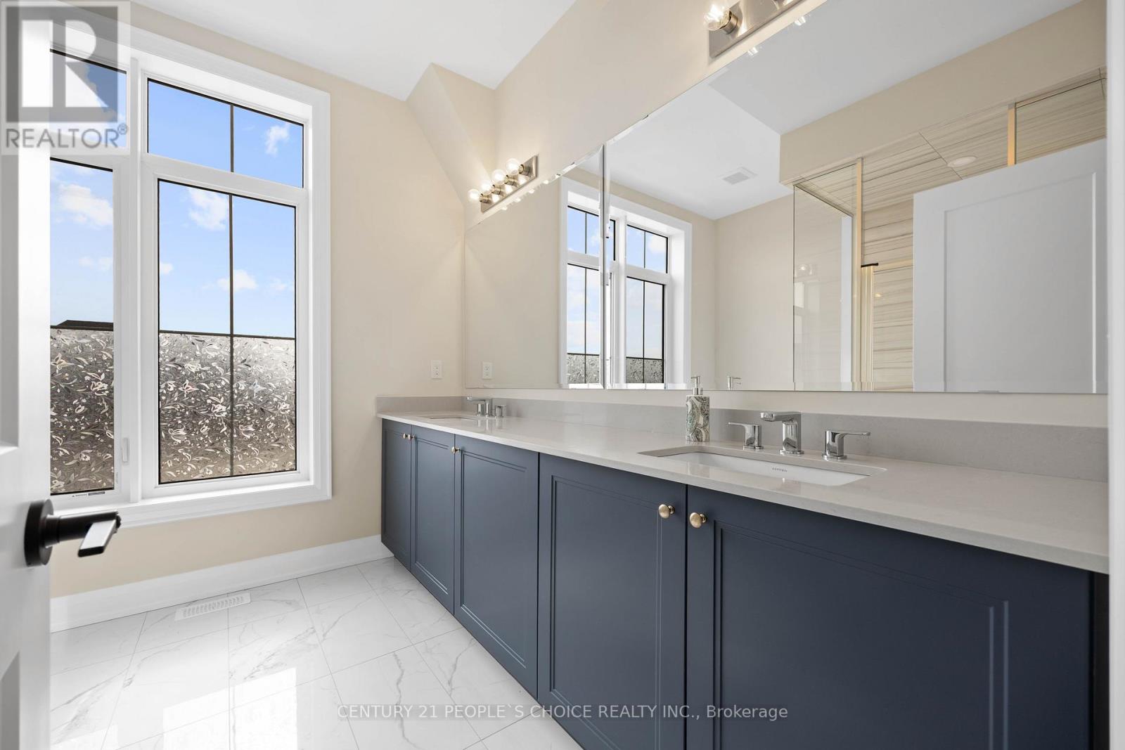 A bathroom with a large mirror and a window with a view of trees.