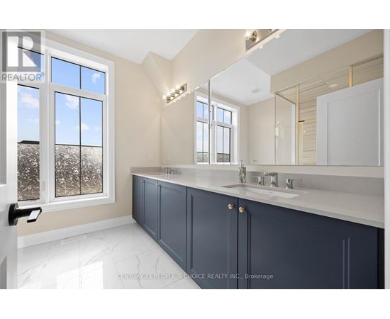A bathroom with a large mirror and a window with a view of trees.