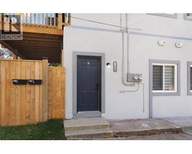 A house with a black door and a wooden fence.